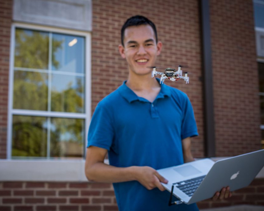 Michael smiling in front of a drone